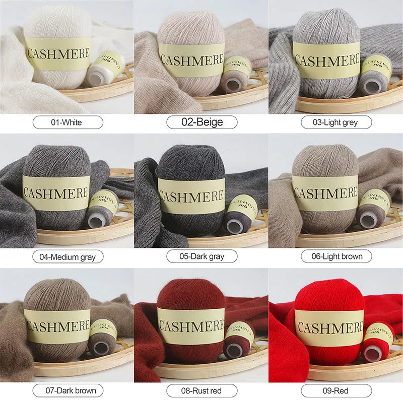 Collection of cashmere yarn balls in various colors with labels on a wooden tray.
