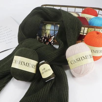 Green cashmere yarn skeins with labels on a white surface